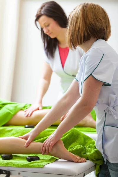 Two female masseuse doing legs massage — Stock Photo, Image