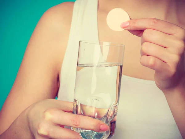 Mujer sosteniendo vidrio con agua y tableta efervescente — Foto de Stock