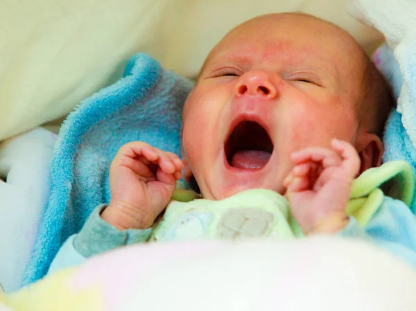 Kleine pasgeboren baby geeuwen in baby cot — Stockfoto