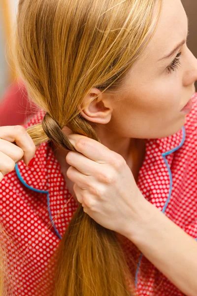 Kobieta robi plecionki na blond włosy — Zdjęcie stockowe