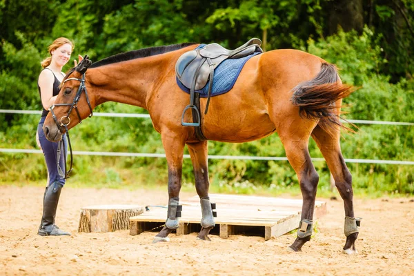 Jockey ung kvinna sig hästen redo för ride — Stockfoto