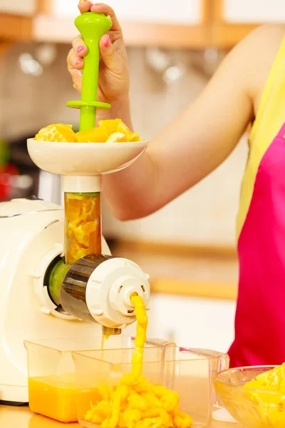 Frau macht Orangensaft in Saftpresse — Stockfoto