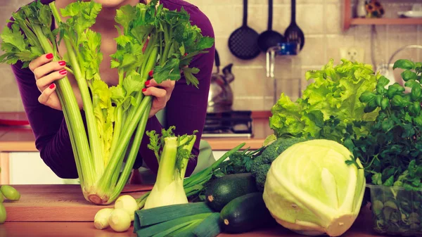 Femme dans la cuisine avec des légumes verts — Photo