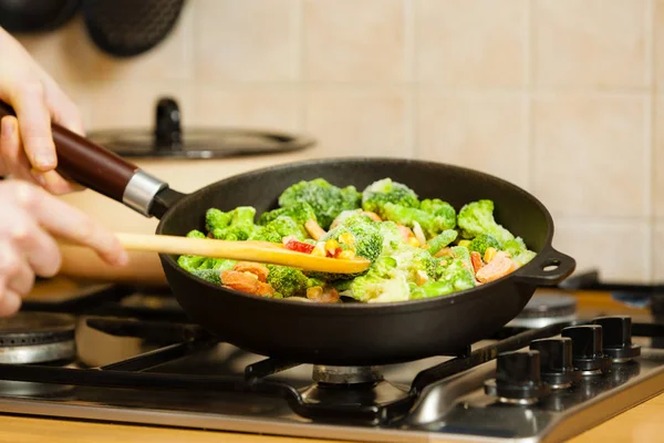 Femme cuisson sauté légumes congelés sur la poêle — Photo