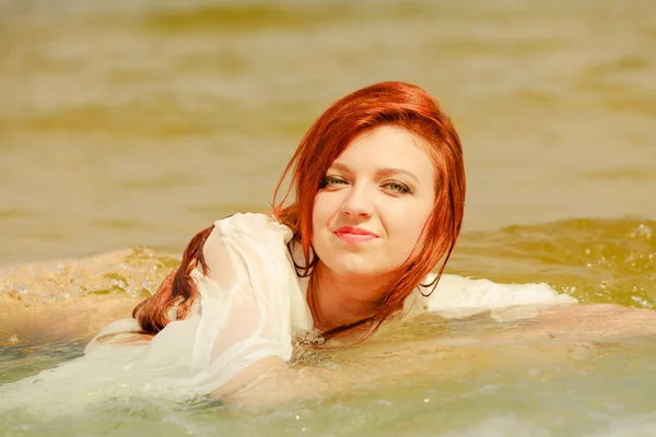 Roodharige vrouw poseren in water gedurende de zomermaanden — Stockfoto