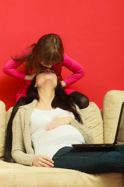 怀孕的女人和女儿坐在一起的笔记本电脑 — 图库照片