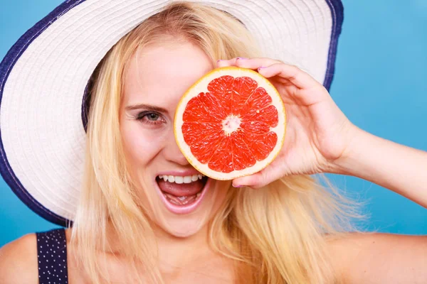 Mulher segurando vermelho toranja fruta wearin chapéu de sol — Fotografia de Stock