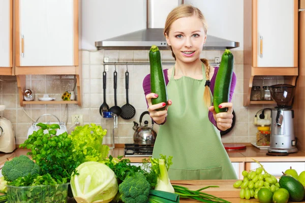 Donna casalinga in cucina con verdure verdi Immagine Stock