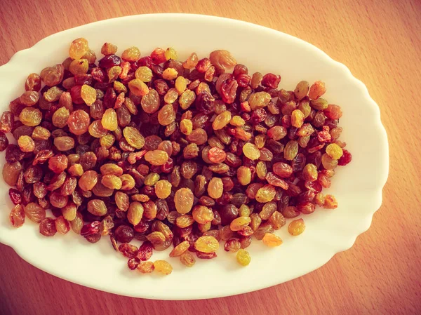 Plate bowl full of yellow dried raisins — Stock Photo, Image