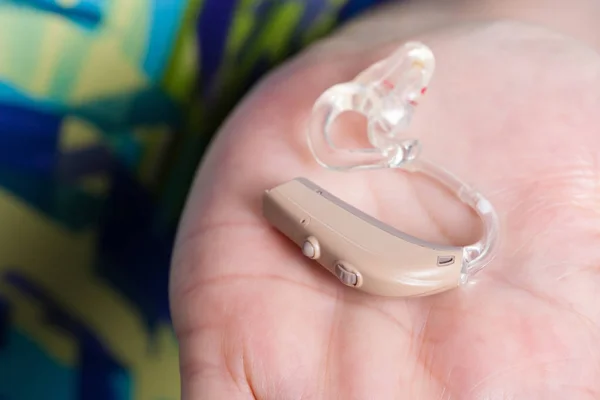 Senior person holding hearing aid closeup — Stock Photo, Image