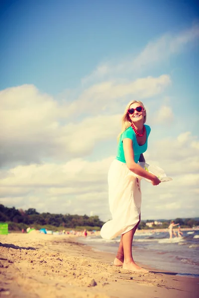 Mulher na praia jogando chapéu de sol — Fotografia de Stock