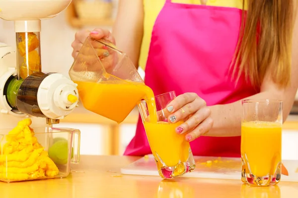 Vrouw gieten jus d'orange drank in glas — Stockfoto