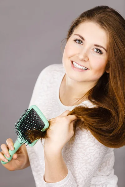 Mulher feliz escovando seu cabelo — Fotografia de Stock