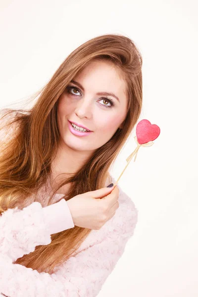 Flirty woman holding red wooden heart on stick — Stock Photo, Image