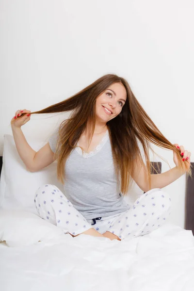 Menina puxando o cabelo na cama . — Fotografia de Stock
