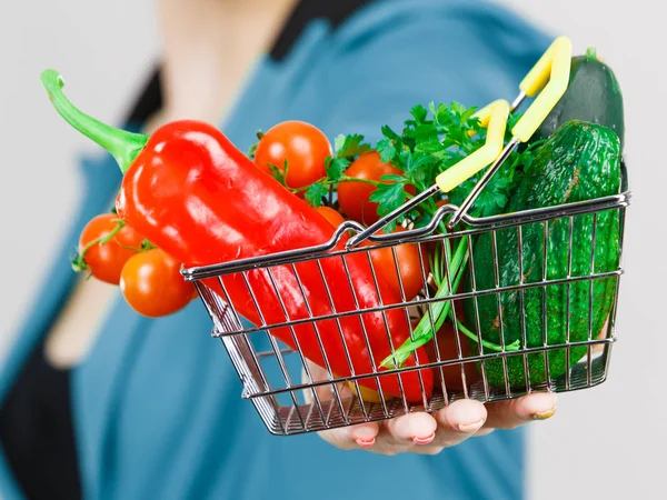 Mulher mão segura cesta de compras com legumes — Fotografia de Stock