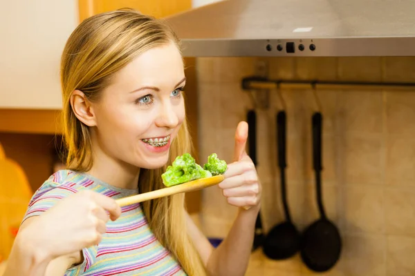 Vrouw proeverij stir fry groente uit de pan — Stockfoto