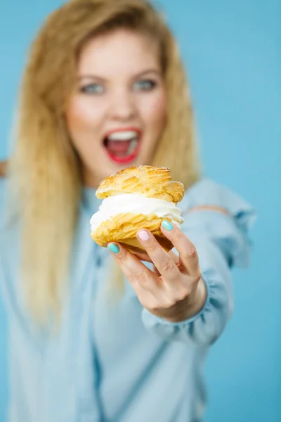 Funny woman holds cream puff cake — Stock Photo, Image