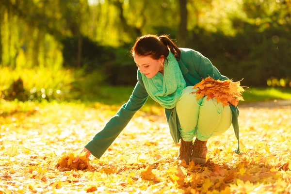 Happy woman collecting leaves in park — Stock Photo, Image