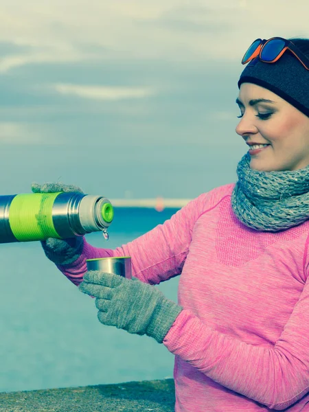 Fitte Frau an kalten Tagen beim Aufwärmen Tee trinken — Stockfoto