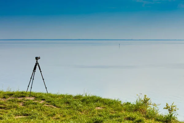 Camera with tripod on coastal cliff — Stock Photo, Image