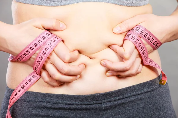 Vrouw aan te raken van maag bedrijf meetlint — Stockfoto