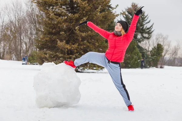 Mujer usando ropa deportiva jugando en la nieve — Foto de Stock
