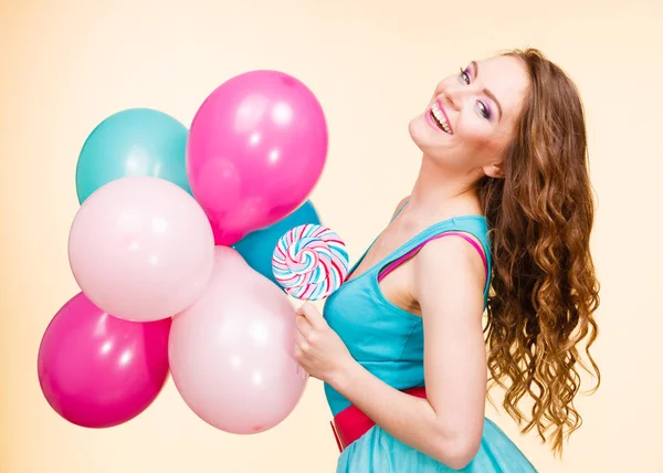 Nainen värikkäiden ilmapallojen ja tikkarin kanssa — kuvapankkivalokuva
