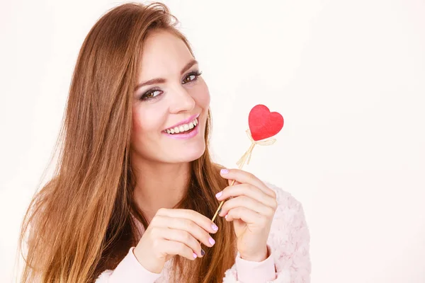 Flirty woman holding red wooden heart on stick — Stock Photo, Image