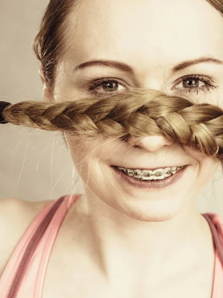 Frau bedeckt ihren Mund mit blondem Zopf — Stockfoto