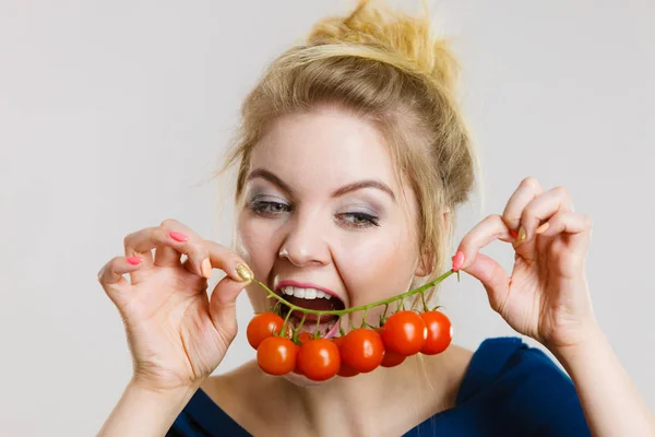 Mulher segurando tomates cereja frescos — Fotografia de Stock