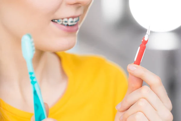 Woman smiling cleaning teeth with braces — Stock Photo, Image
