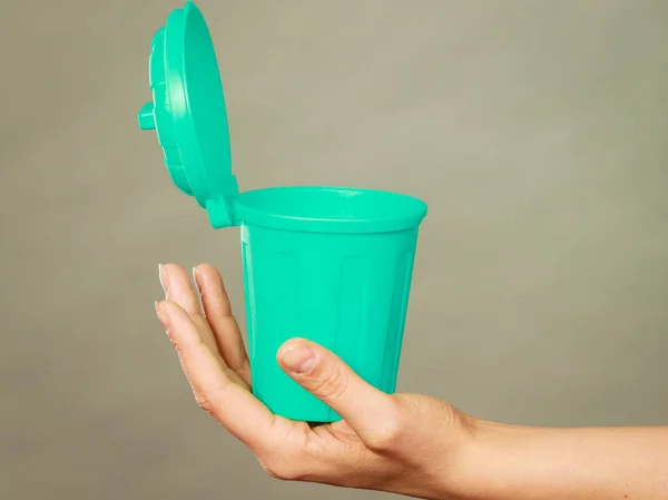 Woman putting paper into small trash can — Stock Photo, Image