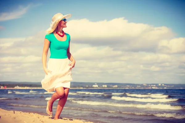 Kobieta blonde noszenie sukienka spaceru na plaży — Zdjęcie stockowe