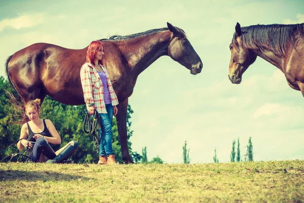 Jockey mujer sentado con caballo en el prado —  Fotos de Stock