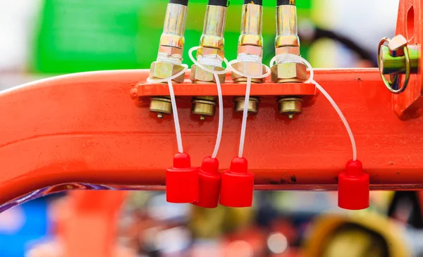 Quatro tubos hidráulicos em máquinas vermelhas — Fotografia de Stock
