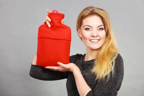 Happy woman holds hot water bottle — Stock Photo, Image