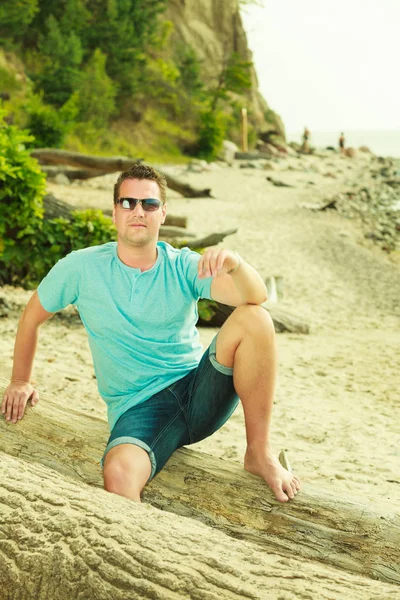 Schöner Mann entspannt sich im Sommer am Strand. — Stockfoto