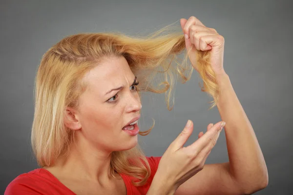 Triste femme regardant cheveux abîmés extrémités — Photo