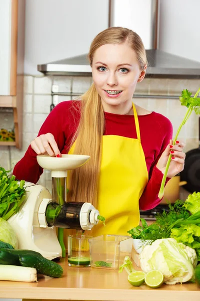 Mulher na cozinha fazendo suco de smoothie vegetal — Fotografia de Stock