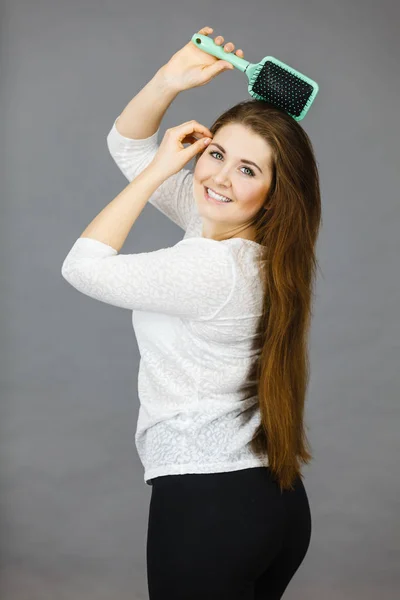 Mulher feliz escovando seu cabelo — Fotografia de Stock