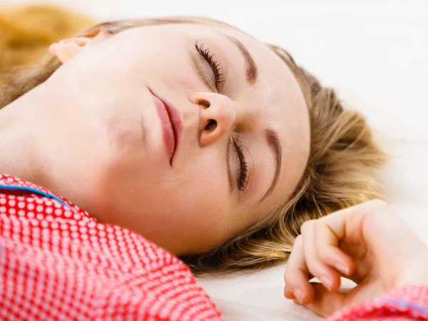 Wanita muda berbaring di tempat tidur mengenakan piyama — Stok Foto