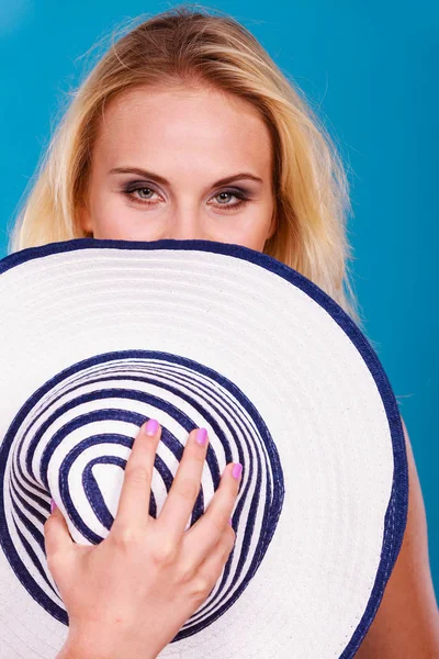 Blonde woman hiding behind sun hat — Stock Photo, Image