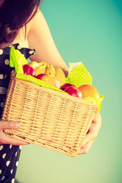 Mujer sosteniendo cesta de picnic con frutas — Foto de Stock