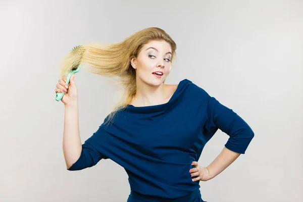 Vrouw haar lange haren borstelen met borstel — Stockfoto
