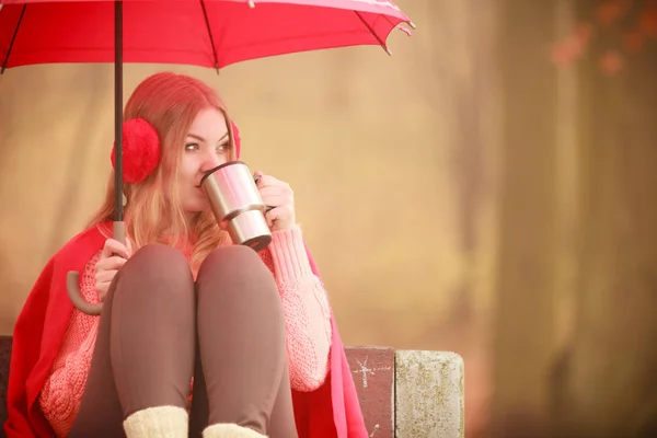 Dziewczyna siedzi w parku z parasolem — Zdjęcie stockowe