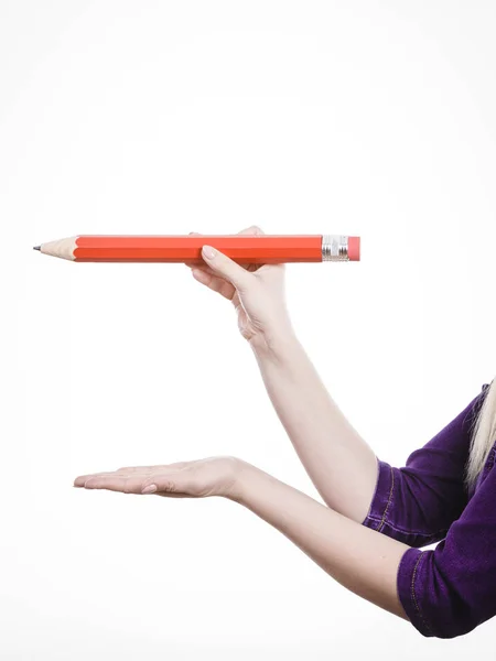 Mano femminile tiene grande matita rossa — Foto Stock