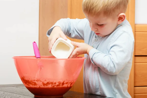 Маленький мальчик готовит пирог в миске — стоковое фото
