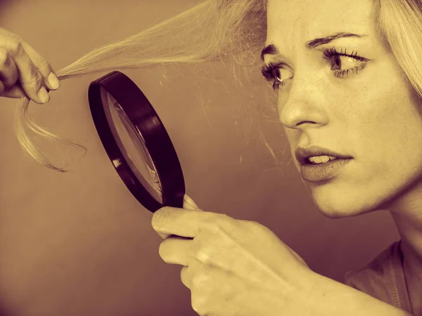 Mulher olhando para o cabelo através de lupa — Fotografia de Stock