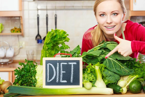 Жінка на кухні має зелені дієтичні овочі — стокове фото